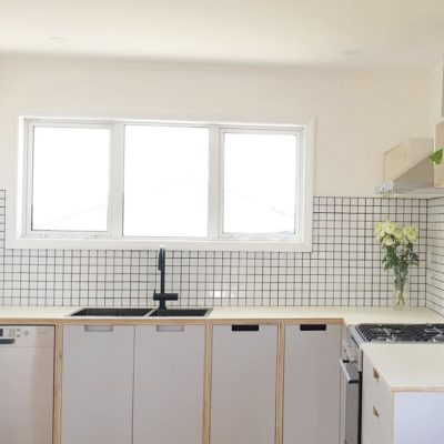 White plywood kitchen with black sink
